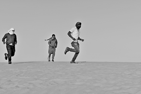 Men running in the desert sand