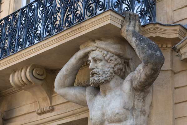 Balcony statue: An old statue supporting a balcony in Aix en Provence, France.