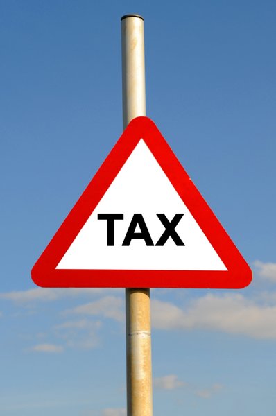 Tax Warning: Triangular tax warning sign against a blue sky