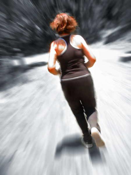 Woman Jogging Blur: Young woman jogging, seen from behind, scenery blurred to denote speed