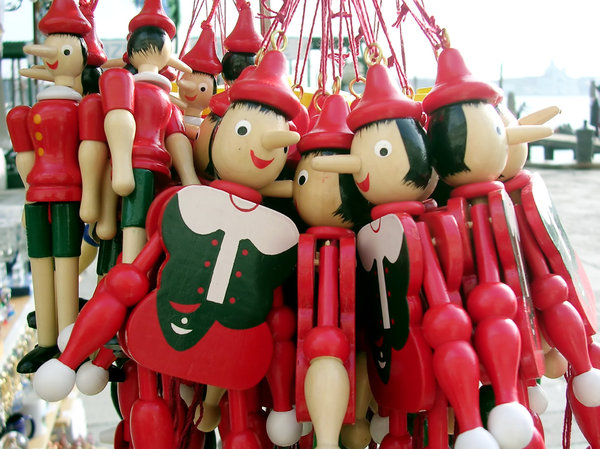 Red dolls: Wooden dolls hanging up on a market stall in Venice.