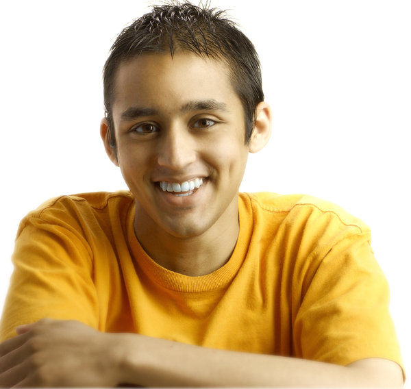 Smiling portrait: portrait of a boy in orange tshirt on a clean white background with good lightingPerson in the Photograph: Nikhil Bhat