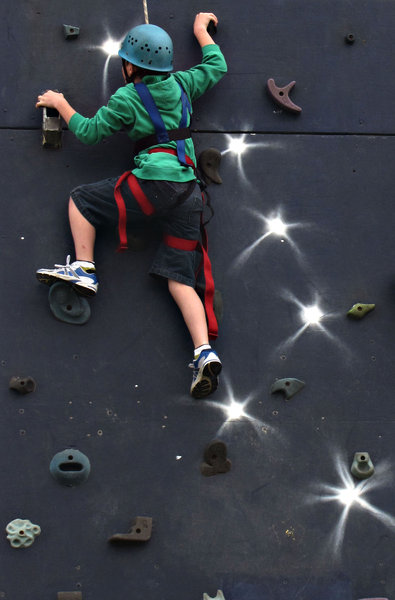 on the way up: boy climbing portable climbing wall