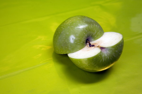 two halfs: two hlfs of green apple on the green vivid background