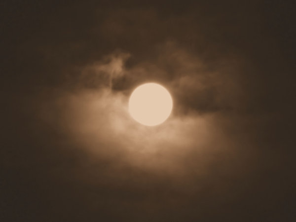 sepia moon: moon halo on cloudy misty evening in old sepia colour