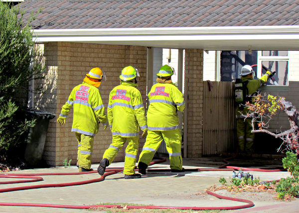 fire & rescue action: fire and rescue team and vehicles attending suburban house fire