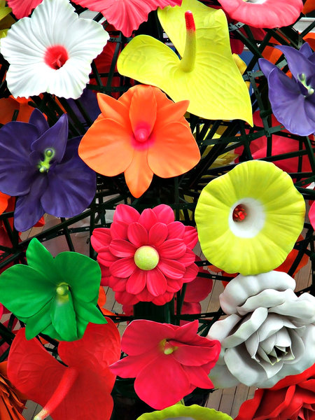 artificial colours: outdoors public display of large colourful plastic flowers