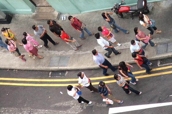 angle on pedestrians: looking down on group of tourist pedestrians sauntering along road