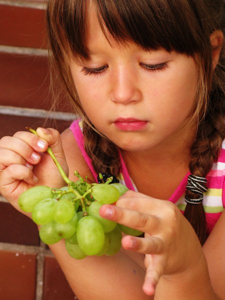 girl eating grapes: none