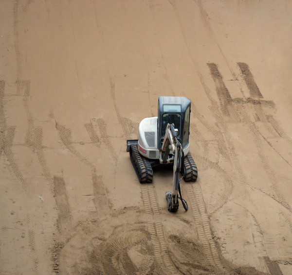playing in the sand: a mini-excavator and sand.