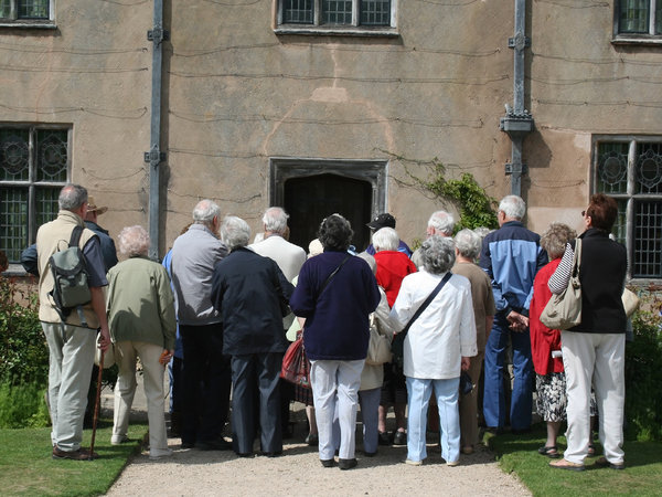 Tour group: A tour group looking at an historic house in England.