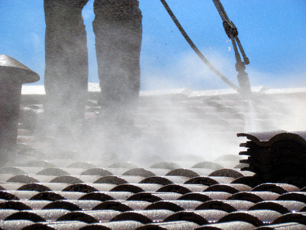 roof restoration4: workman cleaning roof tiles for restoration