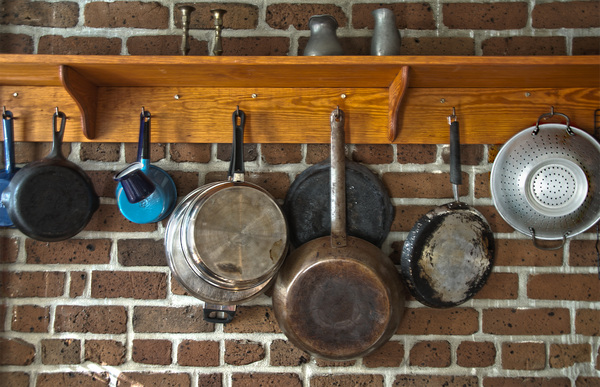 Pots and Pans: Pots and Pans hanging from hooks under a shelf in a southern USA kitchen