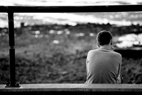 Looking At The Sea: Young man sitting looking out to sea