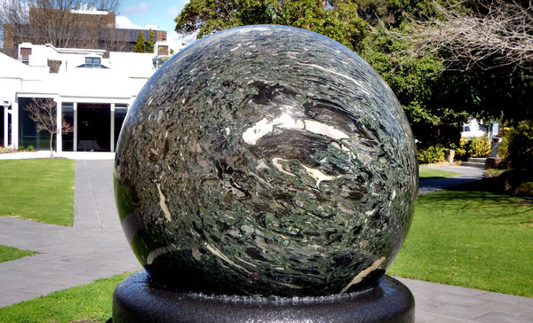 water rotating sphere2: 10 tonne kugel-ball of brecciated marble and granulitic schist floating on water on black granite base