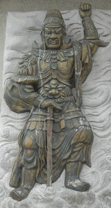 Stone Warrior: stone carving on foot of a Buddha statue.