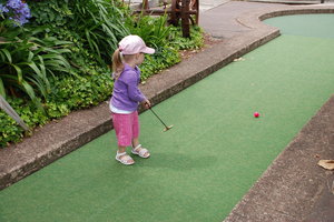 Mini golf: Young girl playing mini golf