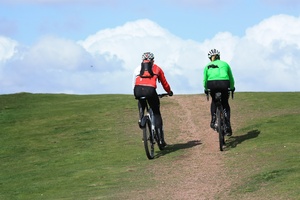 Cyclists off road: Pair of cyclists heading for the horizon, off road on a hill