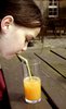 orange juice: Child drinking a glass of juice through a straw