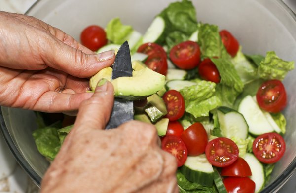 Dinner Salad: Cutting up the avocado on top of the salad.