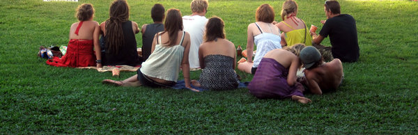 Small group: Small group of fans sitting on grass watching a local band. Sorry about the crop. There's no more grass after the crop at the top, but maybe someone will find it useful.