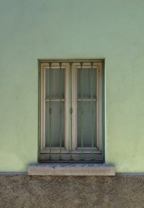 green window: window with bars on a green wall