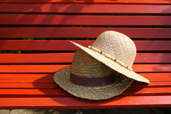 Straw hats: straw hats on a wooden bench.