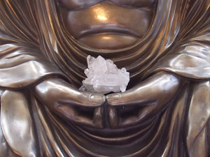 Buddha Holding Crystal: Shot of a crystal in the hands of meditating Buddha statue.