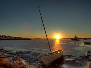 Boat on icy water - HDR: Sailing boat at the shore of a frozen fjord. The picture is HDR.