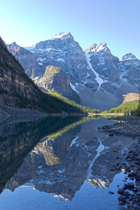 Mountain reflections: Mountains reflected in Lake Moraine, an intensely blue lake of glacial meltwater in western Canada.