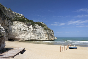Beach, cliff and cave: A beach and chalk cliffs in southern Italy.