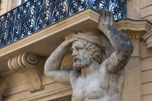 Balcony statue: An old statue supporting a balcony in Aix en Provence, France.