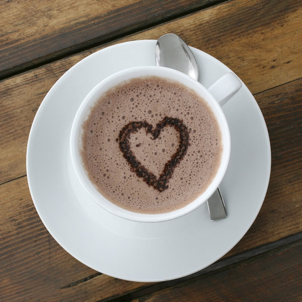 Hot chocolate heart: Heart-shaped sprinkles in a cup of hot milky chocolate.