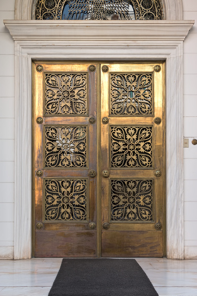 Ornamental brass doors: A pair of ornamental brass doors in Athens, Greece.
