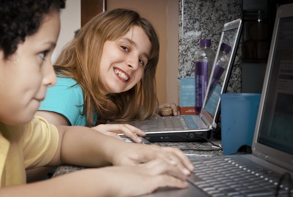 Online kids: A boy and a girl plugged on the web