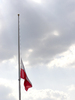 Polish Flag at Half Staff: Lowered flag and the clouds.