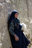 Old Woman: Old persian woman leaning  the wall.