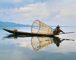 Fisherman's portrait: A fisherman fishing in his boat on Inlay lake, Myanmar.Peaceful image prepared to be your desctop wallpaper, any comments are welcome.