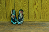 Flip-Flops on the wall: Sandals & Flip-Flops on the wall in the corner of the floor and wall inside the house., the floor is wooden and the wall also made of wood panels and the sandals are in beautiful colours