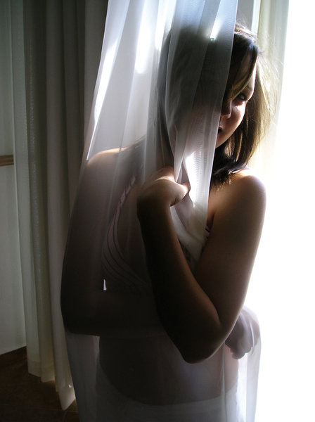 Sexy and Shy: A gorgeous woman draped in a curtain