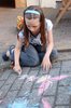 Pavement artist 2: Young girl drawing on a pavement, with permission, with chalks.