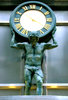 the weight of time: ornamental clock and statue on historic city building