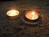 candles in the sand: lit devotional candles in sand