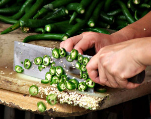 chillie chop: food handler chopping up green chillies