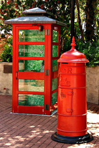 communicate in red: historic and traditional red telephone booth and postal letter collection box