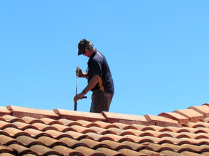 roof restoration1: workman cleaning roof tiles for restoration