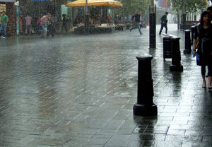 running in the rain1: sunshine and rain downpour near historic city arcade