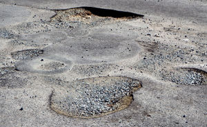 pothole damage4: dried out heavy rain damaged road surface - potholes