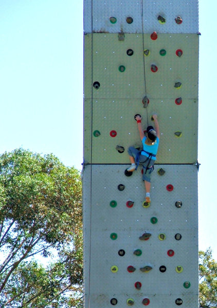 on the way up: girl climbing portable climbing wall