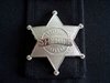 Sheriff: Silver sheriff badge on a black cloth background